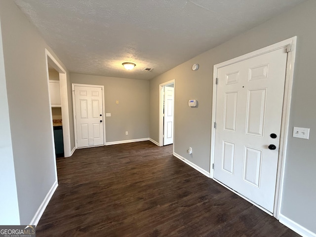 entryway featuring dark hardwood / wood-style flooring and a textured ceiling