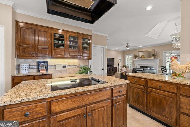 kitchen with black electric cooktop, ornamental molding, light stone counters, and backsplash