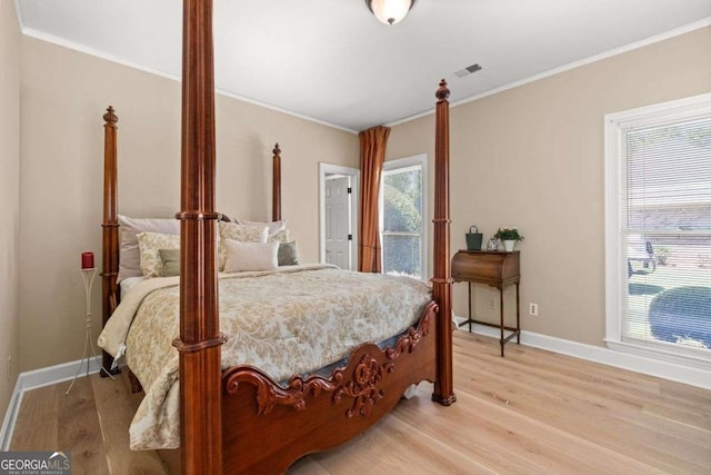 bedroom featuring ornamental molding and light hardwood / wood-style floors