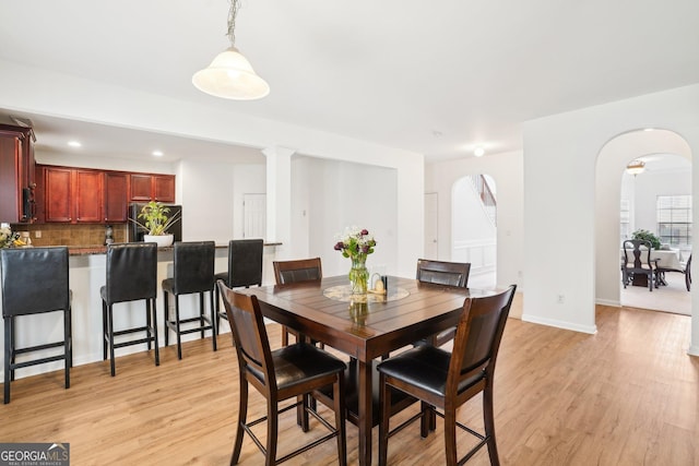 248 Allegrini Dr, Atlanta, GA 30349 - dining area featuring light wood-style flooring, arched walkways, baseboards, and recessed lighting