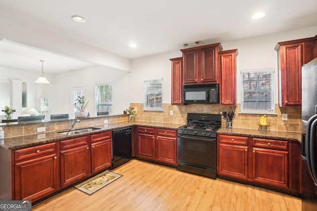 248 Allegrini Dr, Atlanta, GA 30349 - kitchen with a sink, light wood-style floors, dark brown cabinets, backsplash, and black appliances