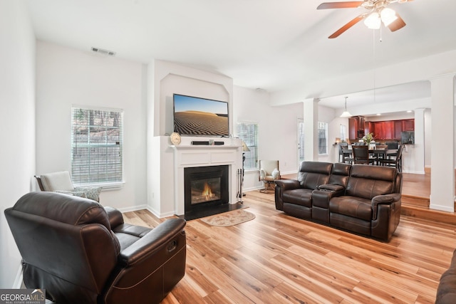 248 Allegrini Dr, Atlanta, GA 30349 - living room featuring light wood finished floors, a large fireplace, baseboards, visible vents, and ornate columns