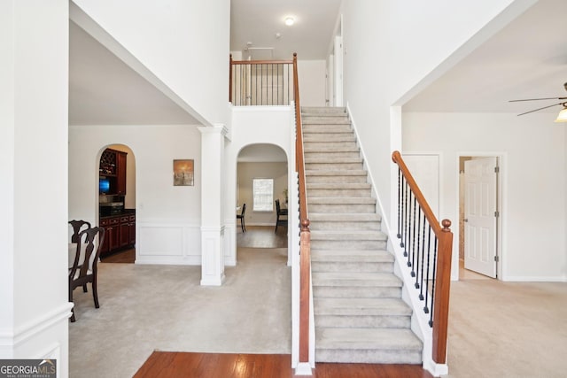 248 Allegrini Dr, Atlanta, GA 30349 - entrance foyer with light carpet, ornate columns, arched walkways, and a ceiling fan
