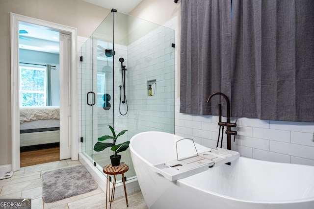 ensuite bathroom featuring ensuite bathroom, a freestanding bath, a shower stall, and tile patterned floors