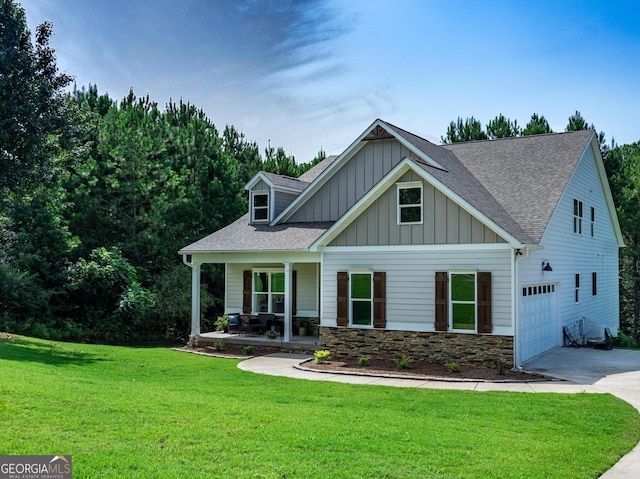 craftsman house featuring concrete driveway, stone siding, covered porch, a front lawn, and board and batten siding