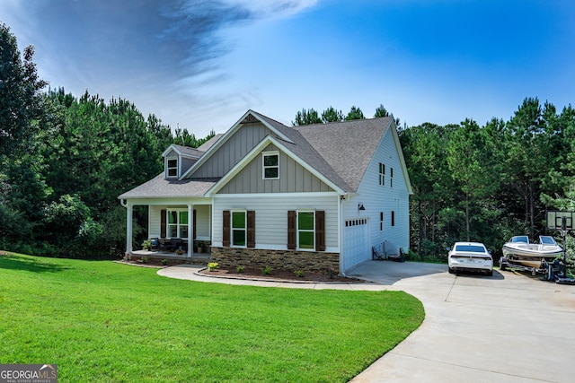 craftsman house with driveway, stone siding, a porch, a front lawn, and board and batten siding