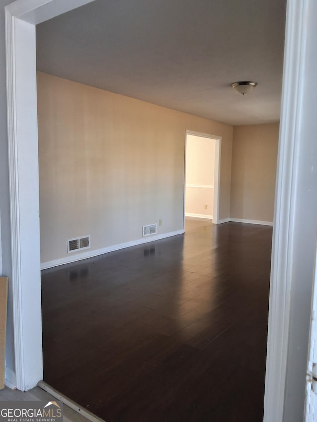 unfurnished room featuring dark hardwood / wood-style flooring