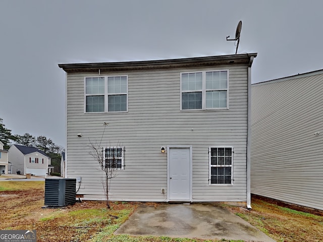 rear view of property featuring central AC unit and a patio area