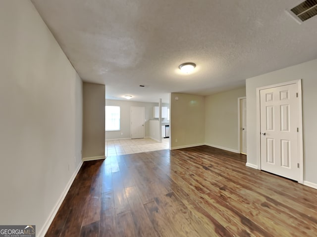 unfurnished room featuring hardwood / wood-style floors and a textured ceiling