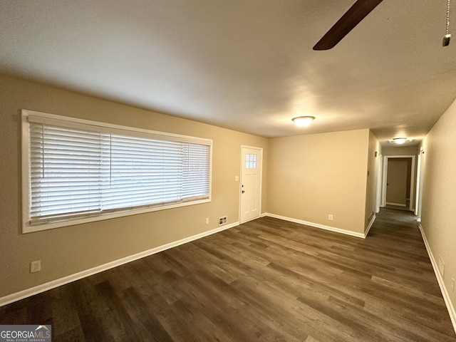 spare room with dark hardwood / wood-style floors and ceiling fan