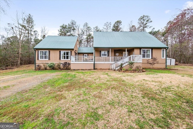 view of front of property featuring covered porch and a front lawn