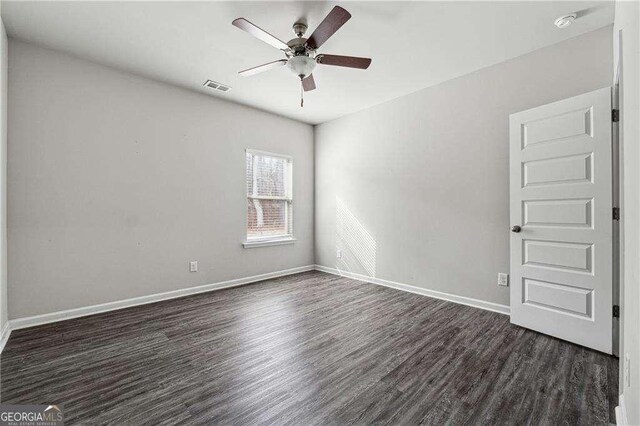 unfurnished room with ceiling fan and dark hardwood / wood-style flooring