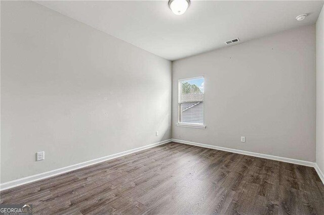 unfurnished room with dark wood-type flooring