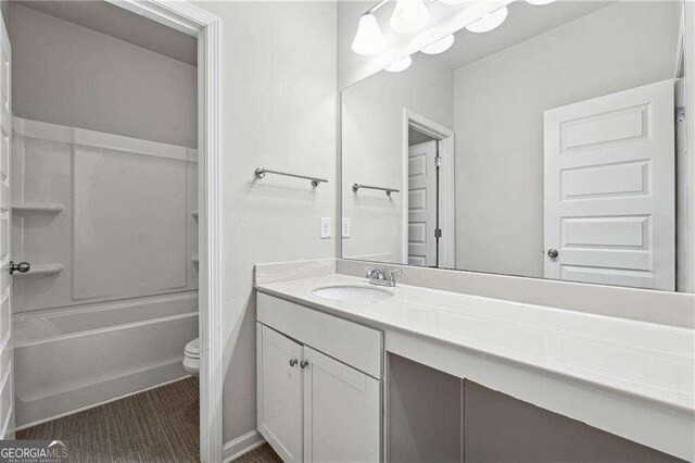 full bathroom featuring vanity, hardwood / wood-style floors, shower / washtub combination, and toilet