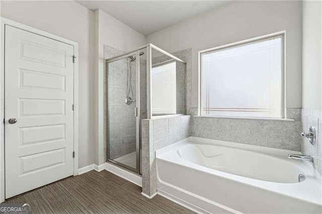 bathroom with independent shower and bath and hardwood / wood-style floors