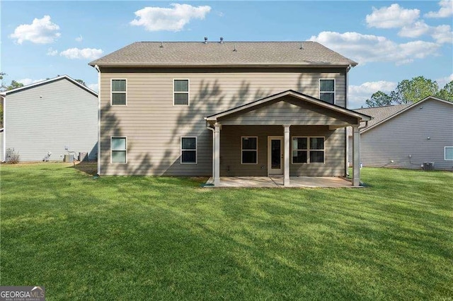 back of house with a lawn and a patio