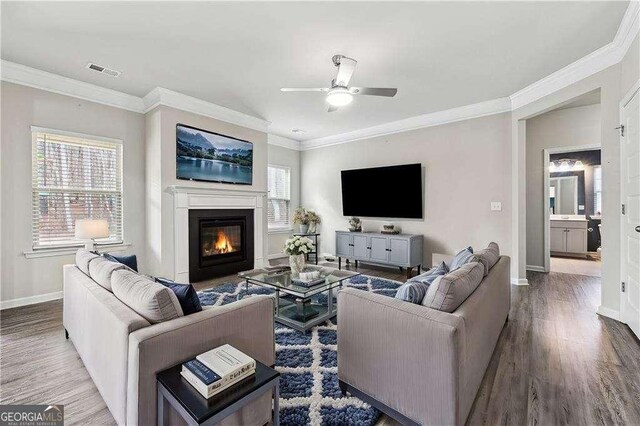 living room featuring ceiling fan, ornamental molding, hardwood / wood-style floors, and a wealth of natural light