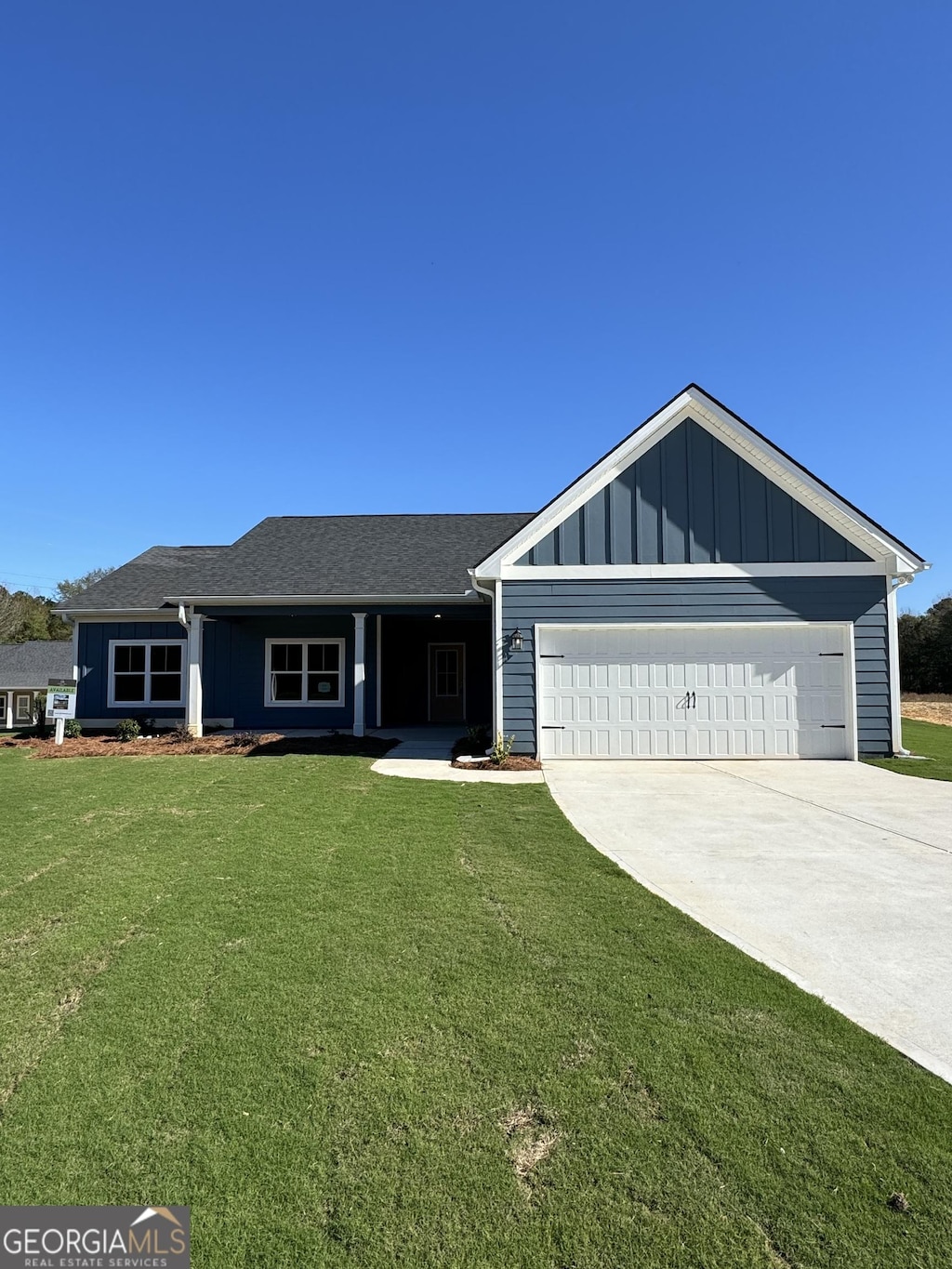 single story home featuring a garage and a front lawn