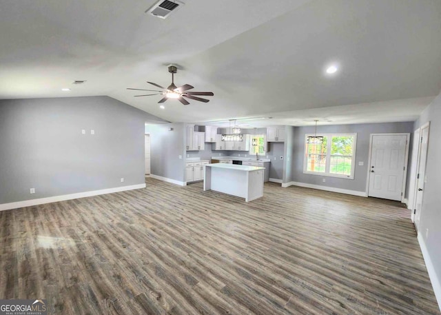 unfurnished living room featuring ceiling fan, vaulted ceiling, and dark hardwood / wood-style flooring