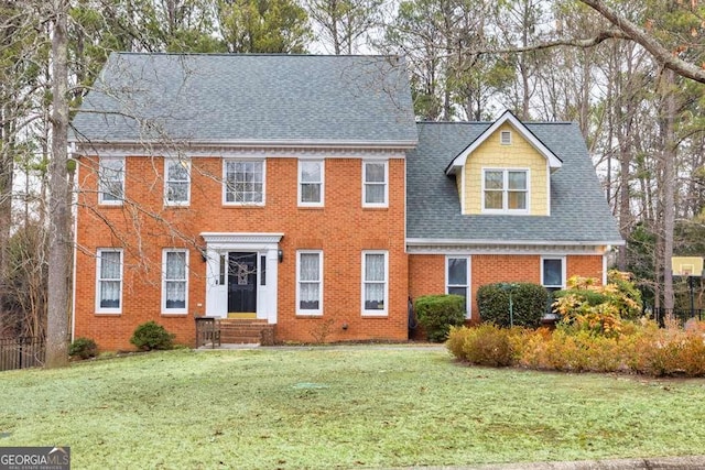 colonial home featuring a front lawn