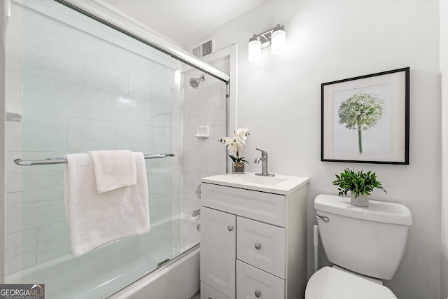 full bathroom featuring vanity, bath / shower combo with glass door, and toilet