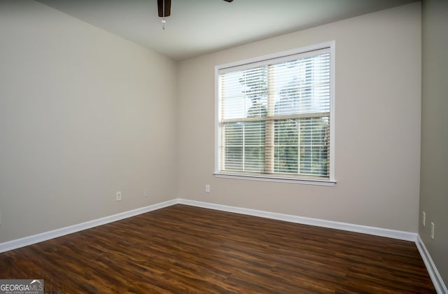 spare room with dark wood-type flooring and ceiling fan