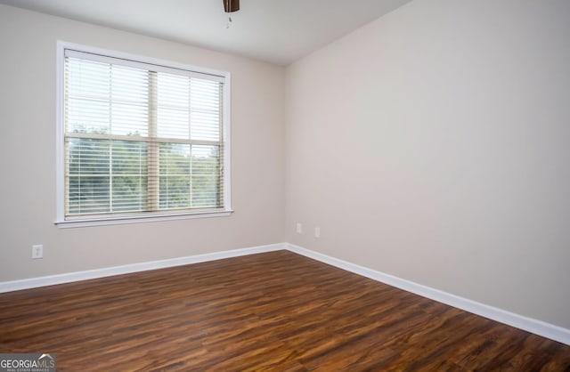 spare room with dark wood-type flooring and ceiling fan