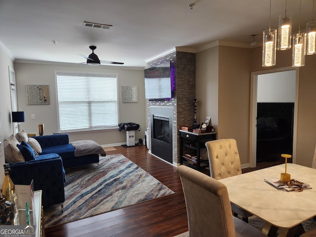 living room with crown molding, dark hardwood / wood-style flooring, and a fireplace