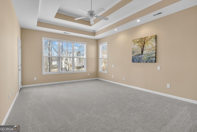 unfurnished room featuring a raised ceiling, carpet, visible vents, and ceiling fan