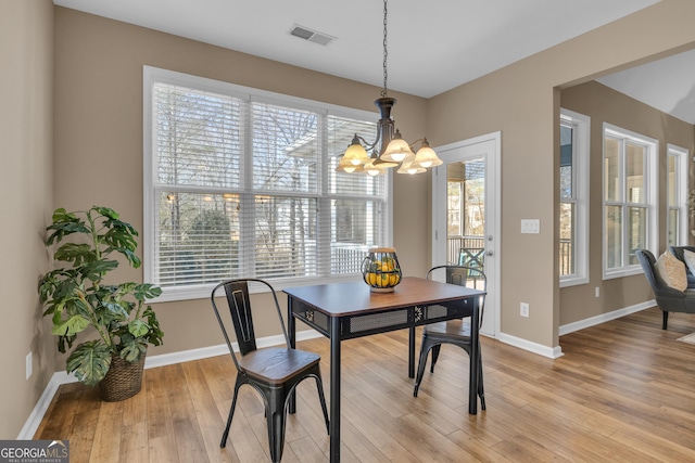 dining area featuring plenty of natural light, baseboards, and an inviting chandelier