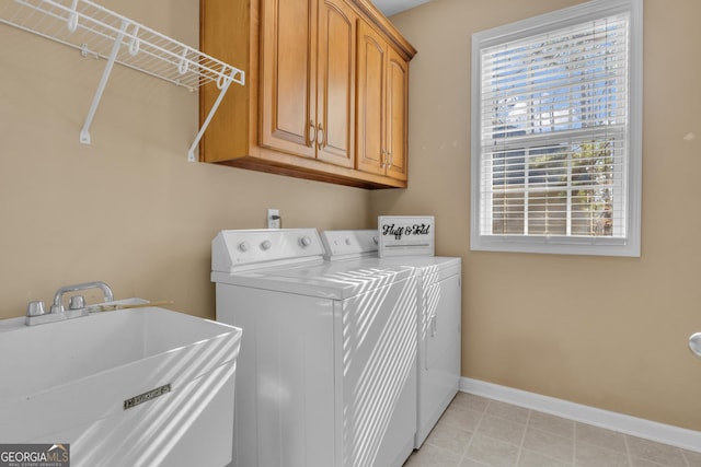 laundry area featuring separate washer and dryer, baseboards, a sink, and cabinet space