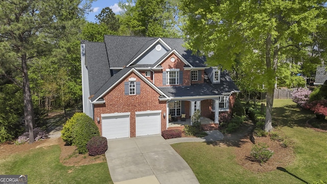 view of front of house featuring concrete driveway, a front yard, covered porch, and brick siding