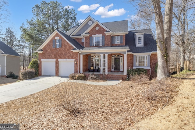 traditional-style home featuring a shingled roof, an attached garage, covered porch, brick siding, and driveway
