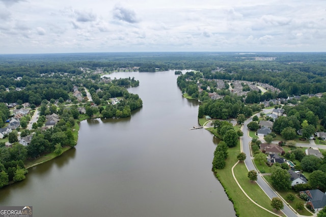 drone / aerial view featuring a view of trees and a water view