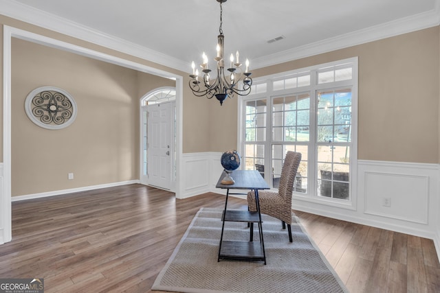 office with crown molding, wood finished floors, an inviting chandelier, and wainscoting