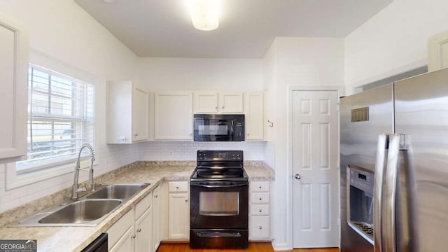 kitchen featuring sink, decorative backsplash, black appliances, and white cabinets