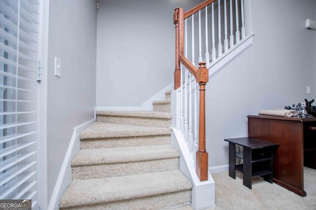 unfurnished bedroom with ensuite bathroom, a spacious closet, light colored carpet, a closet, and ceiling fan