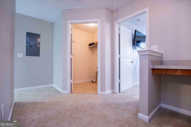 hallway featuring light colored carpet and electric panel