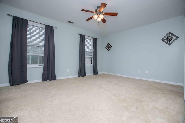 carpeted spare room featuring ceiling fan