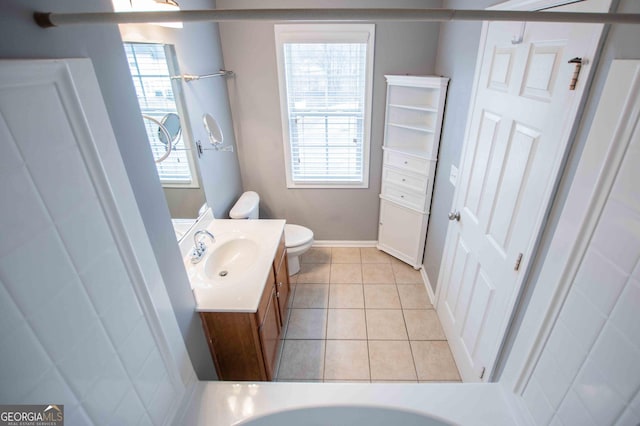 bathroom featuring a healthy amount of sunlight, toilet, tile patterned flooring, and vanity