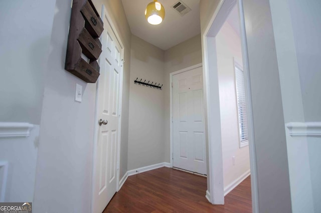 corridor with dark hardwood / wood-style flooring