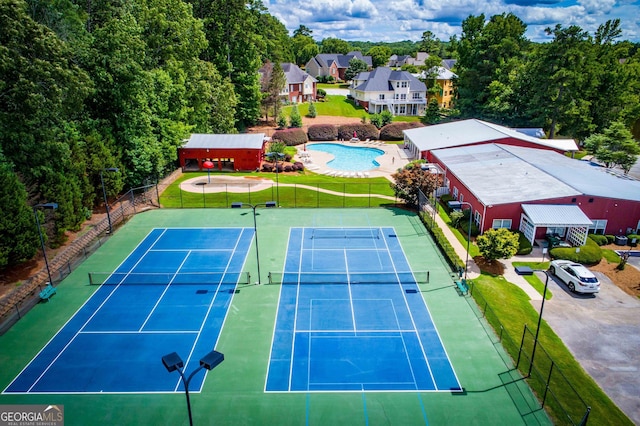 view of tennis court with a lawn