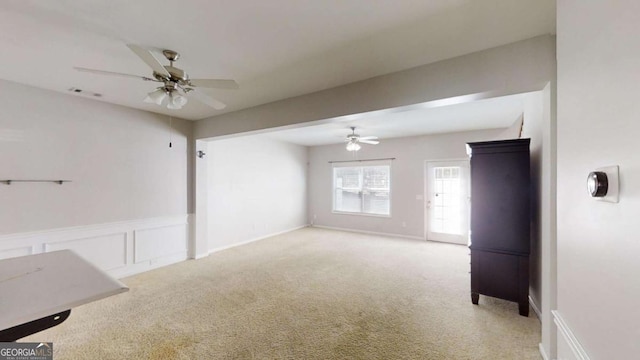 unfurnished living room featuring ceiling fan and light carpet