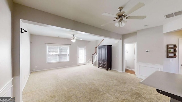 unfurnished living room with light carpet and ceiling fan