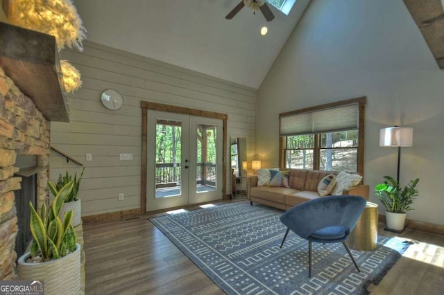 living room featuring a fireplace, high vaulted ceiling, hardwood / wood-style flooring, ceiling fan, and french doors