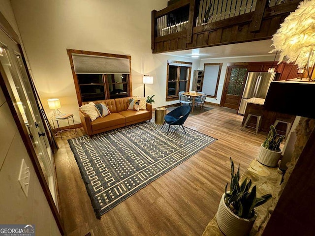 living room with a towering ceiling and light wood-type flooring