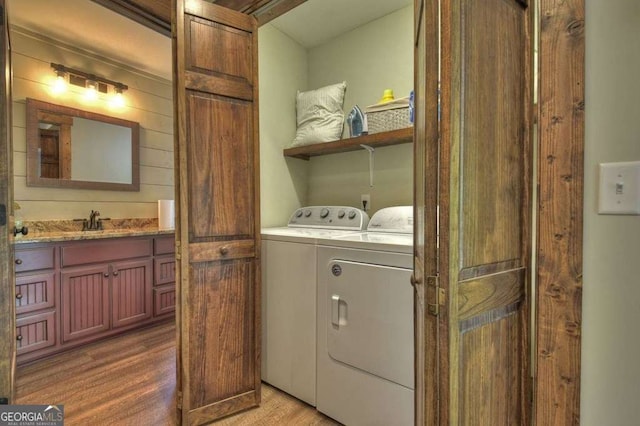 laundry area with wood-type flooring, sink, and independent washer and dryer