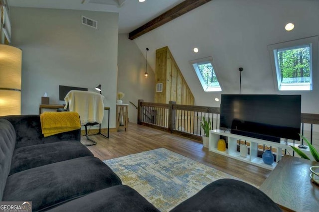 living room featuring beamed ceiling, a healthy amount of sunlight, high vaulted ceiling, and light hardwood / wood-style flooring