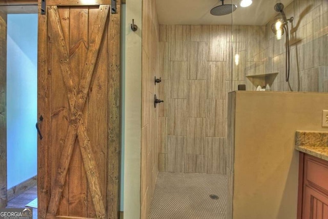 bathroom with vanity and a tile shower