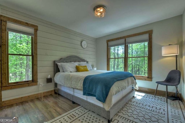 bedroom with wooden walls and hardwood / wood-style floors